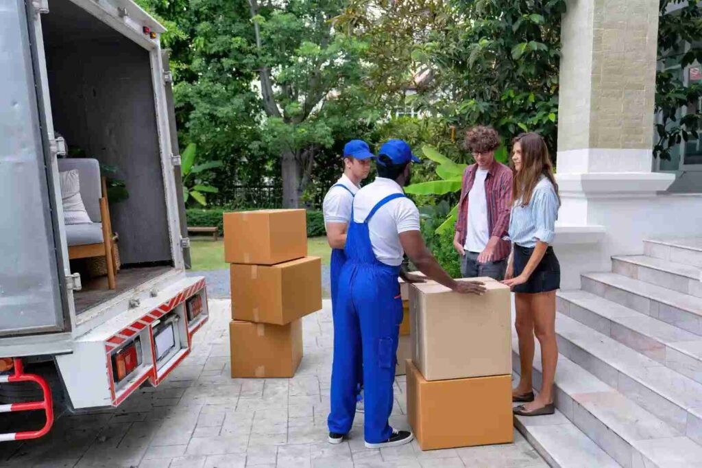Professional movers carefully loading office furniture onto a moving truck.